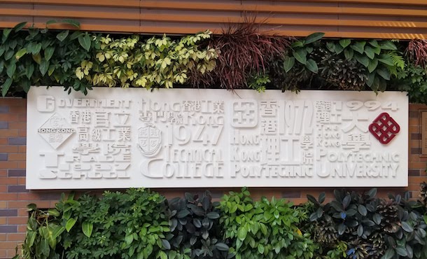 White sign outside Hong Kong Polytechnic University with university name in different languages
